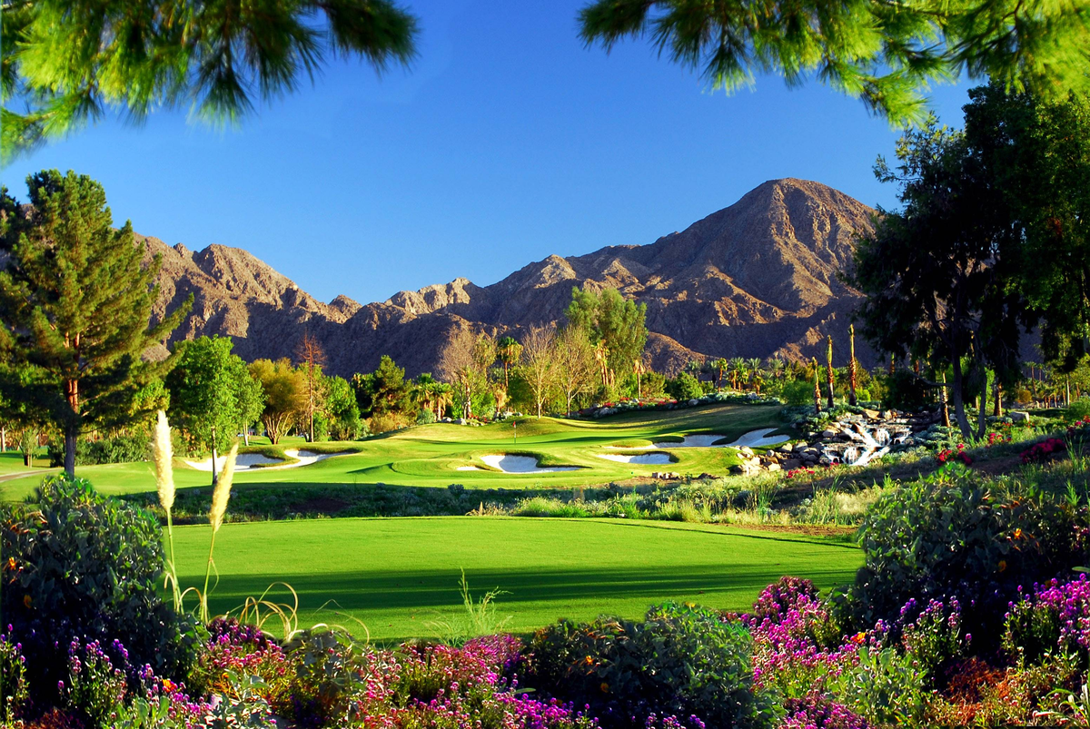 Landscape image of golf course with mountains in the distance.